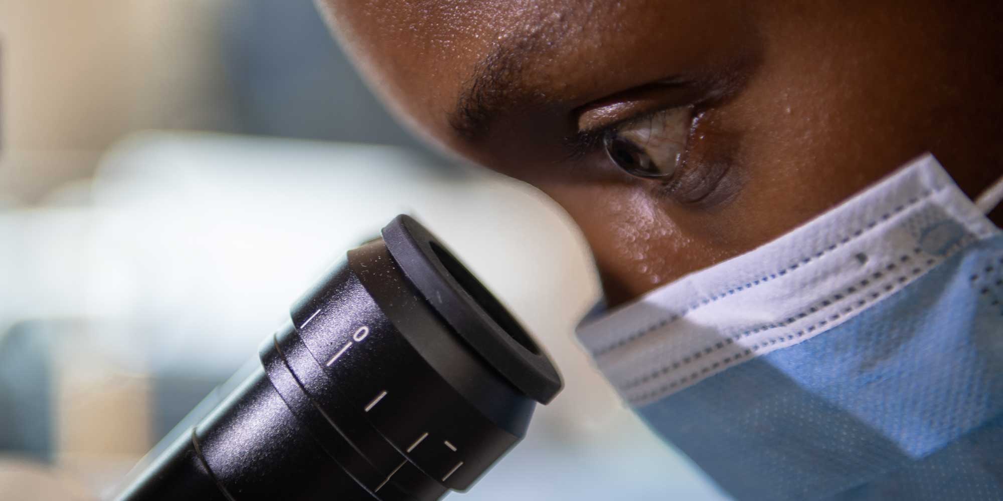 Diverse student looking through microscope/