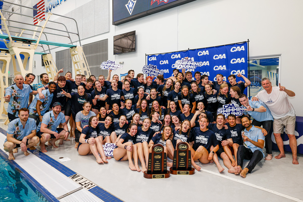 UNCW's swimming and diving teams pose with championship trophies.