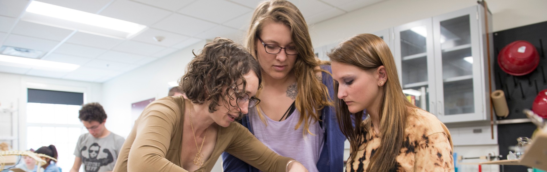 Professor and two students examining a skull in the lab