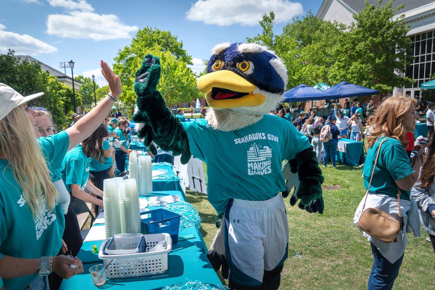 Sammy C. Hawk high fives student