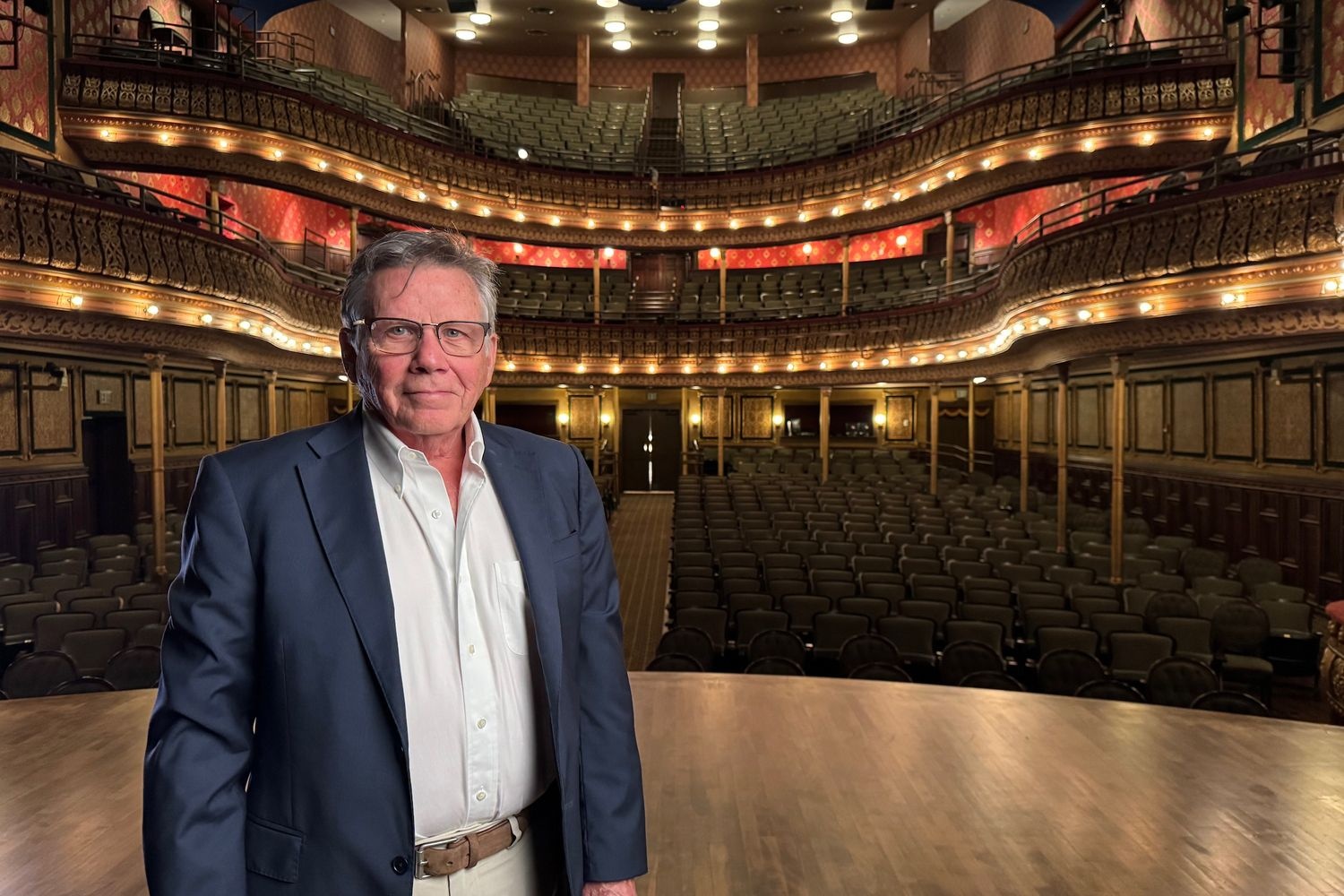 Paul Castagno stands on the stage of MSU's Riley Center