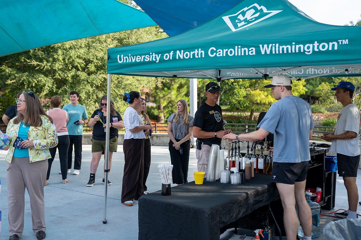 Alumni employees gather for coffee outside on campus