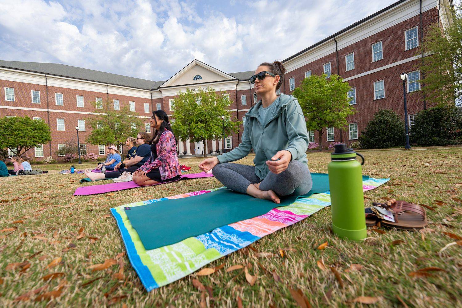 Faculty, staff and students participate in yoga on the lawn during Health and Human Services Week.  