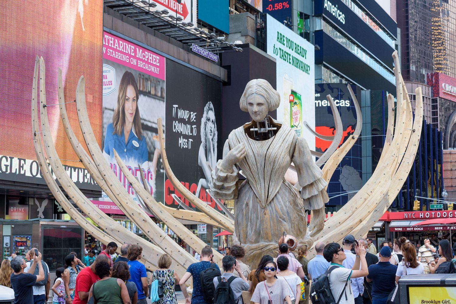 Mel Chin's sculpture Wake, depicting a woman figurehead in the massive remains of a whale, towers over visitors in New York City's Times Square 