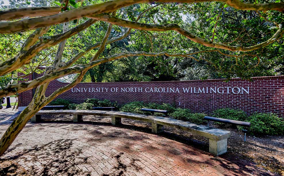 Brick wall with university name in brass letters