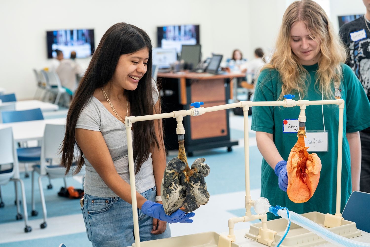 Two iHPSS summer campers touch the pig lung models to learn about Respiratory Therapy.