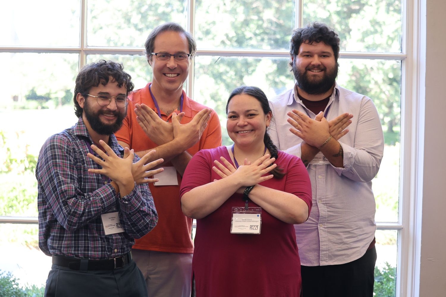 UNCW students and faculty smile and make the "wings up" gesture with their hands