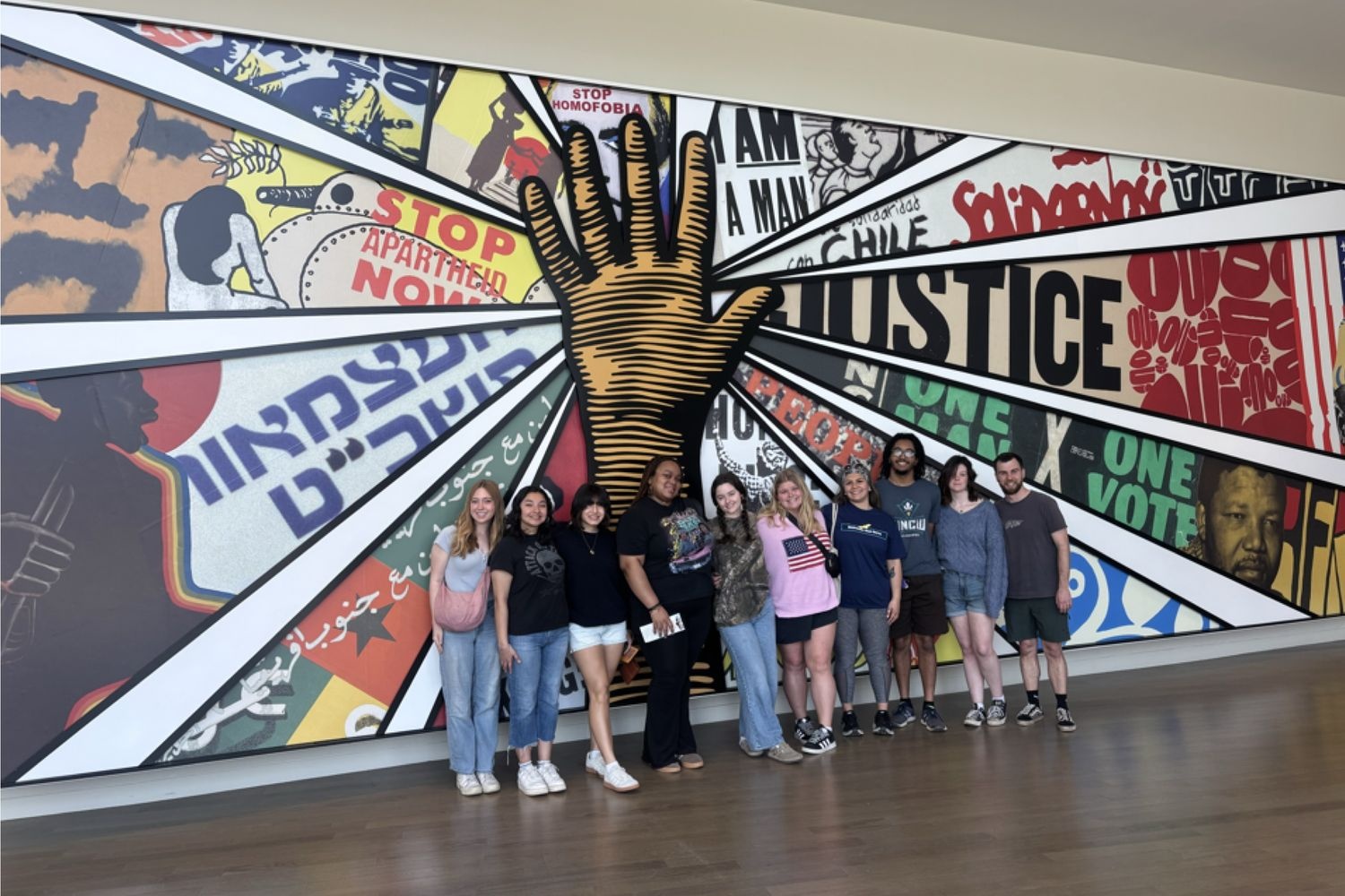 Students standing in front of a unity mural