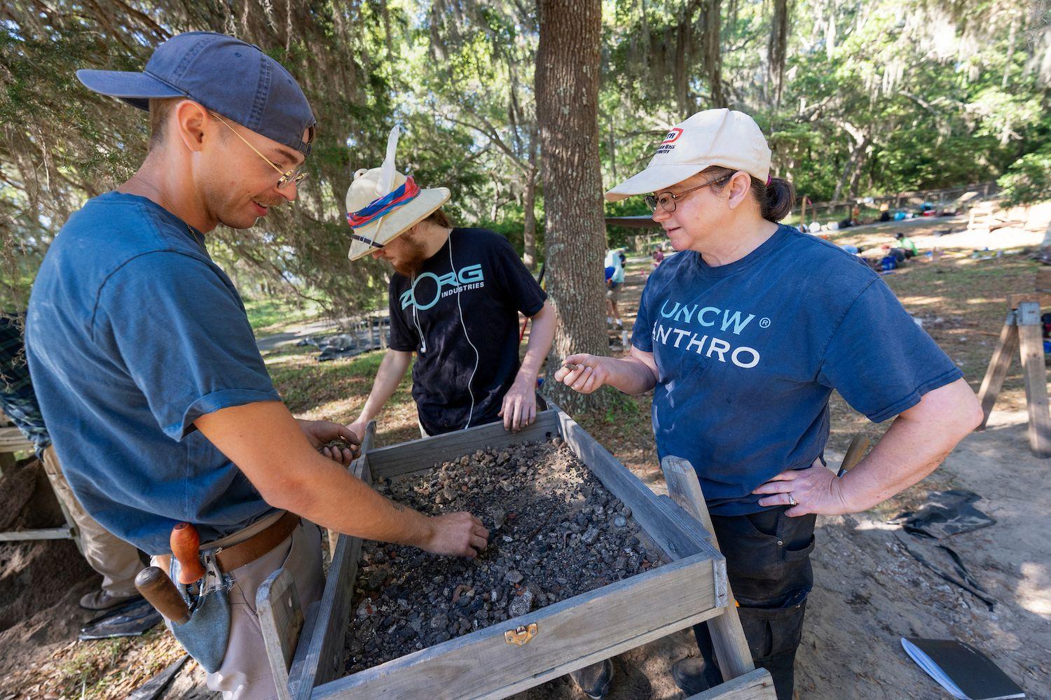 Professor Nora Reber talks to students at a dig site
