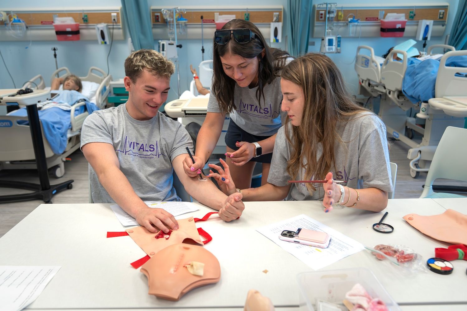 students gathered around table taking vitals