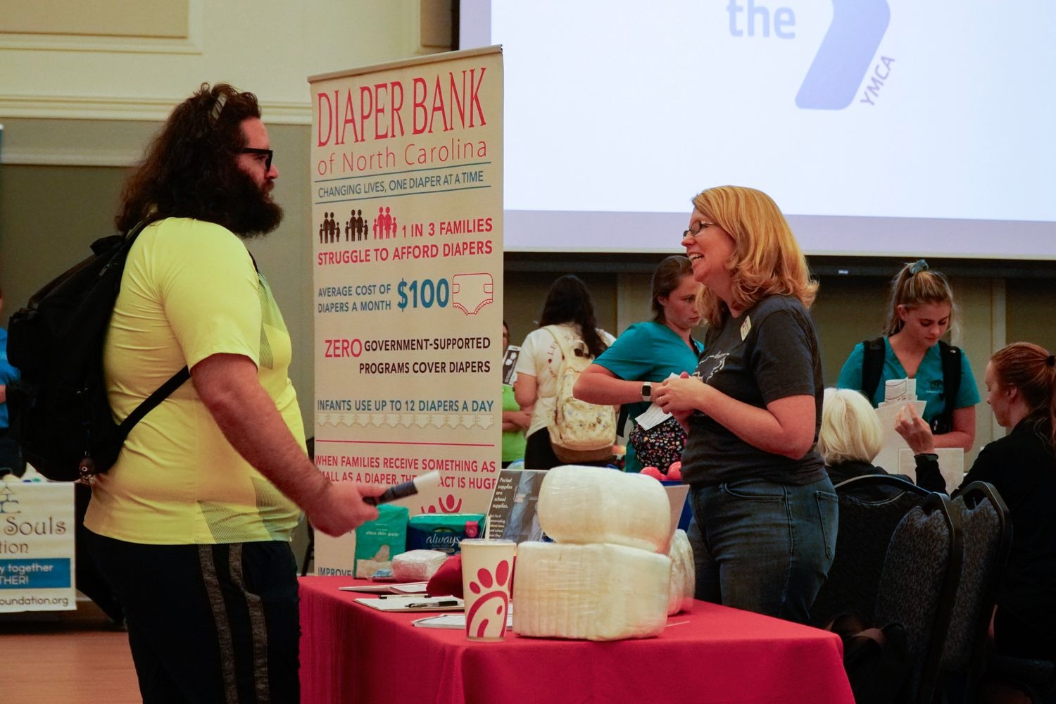 People speaking at a booth for an event