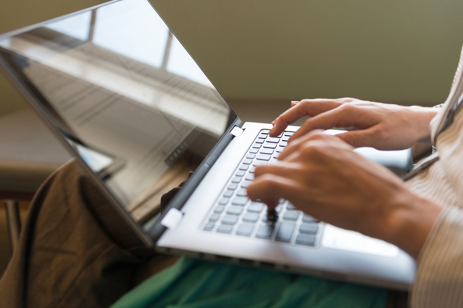 student typing on laptop