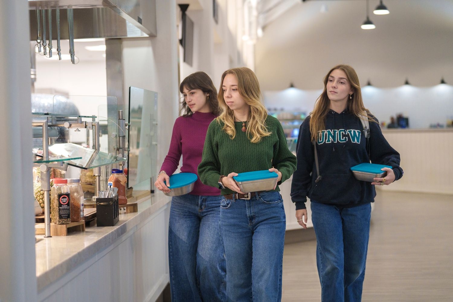 College students with reusable lunch containers in the cafeteria.