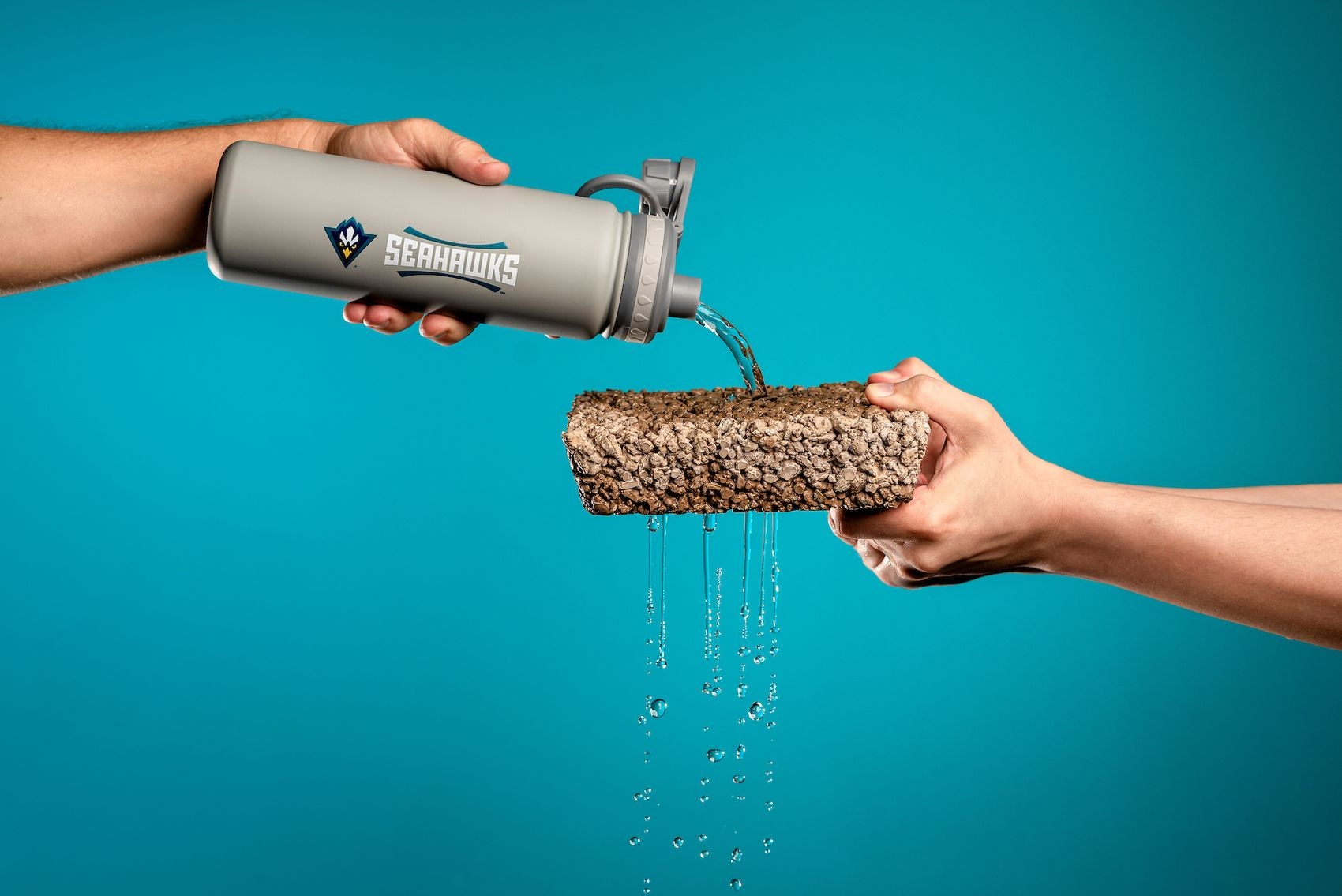 Demonstration of permeable pavement using a water bottle to pour water onto permeable surface. 