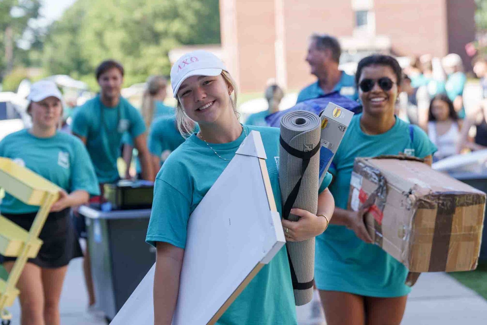 Students carrying items into the dorm for Move in Day.