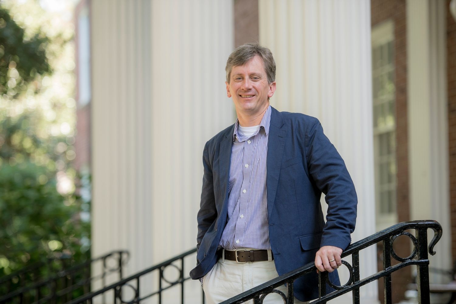 John Scherer poses on steps outside of building