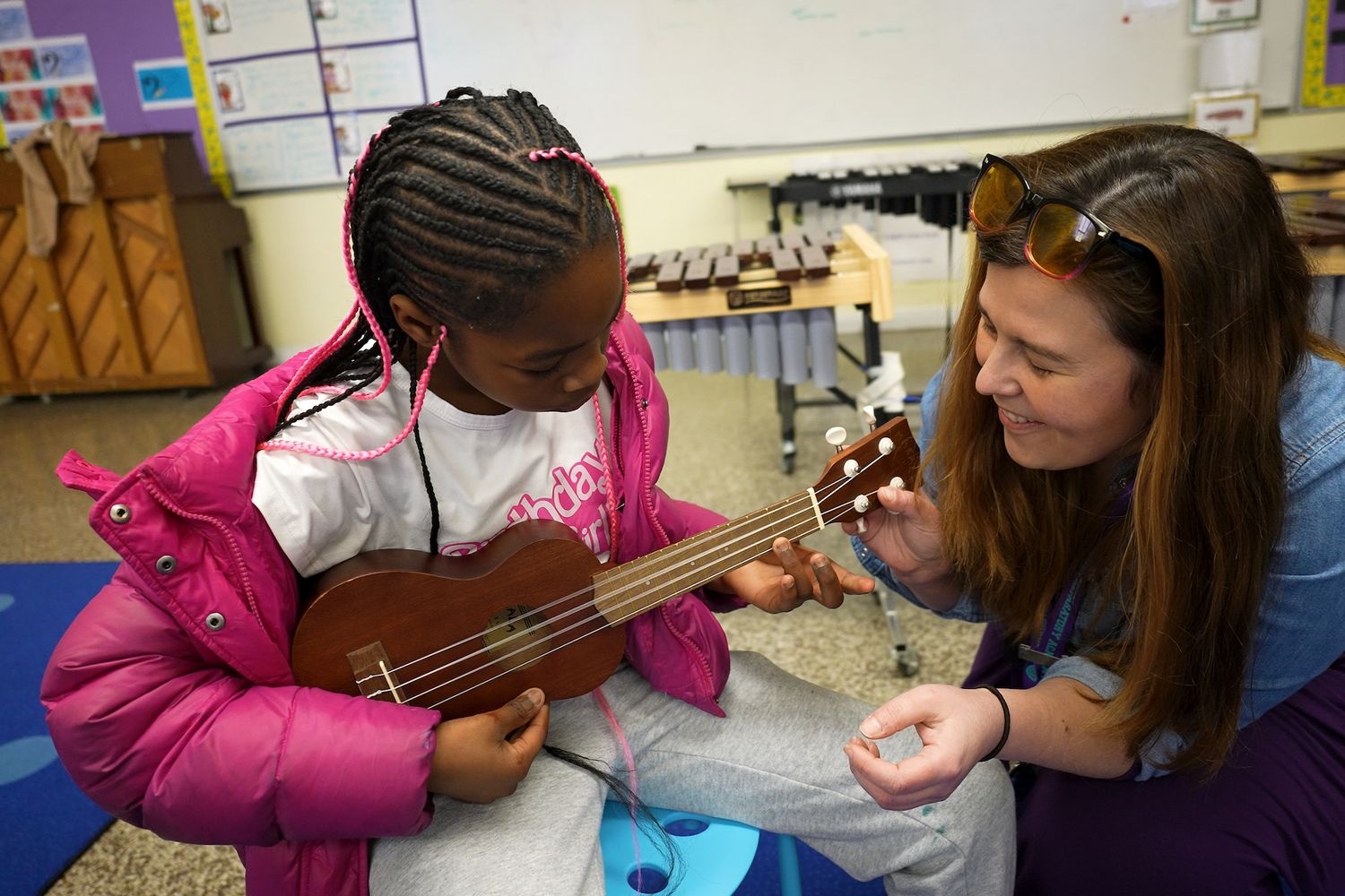 Teacher showing student how to play ukulele