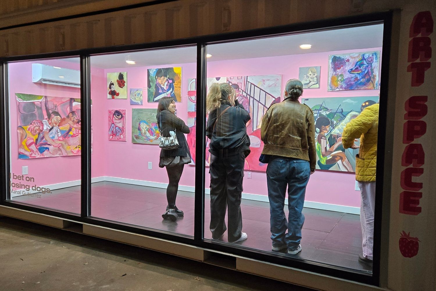 Visitors view UNCW alum Mahal Gutierrez's "I bet on losing dogs" exhibition at the Fried Fruit Art Space.