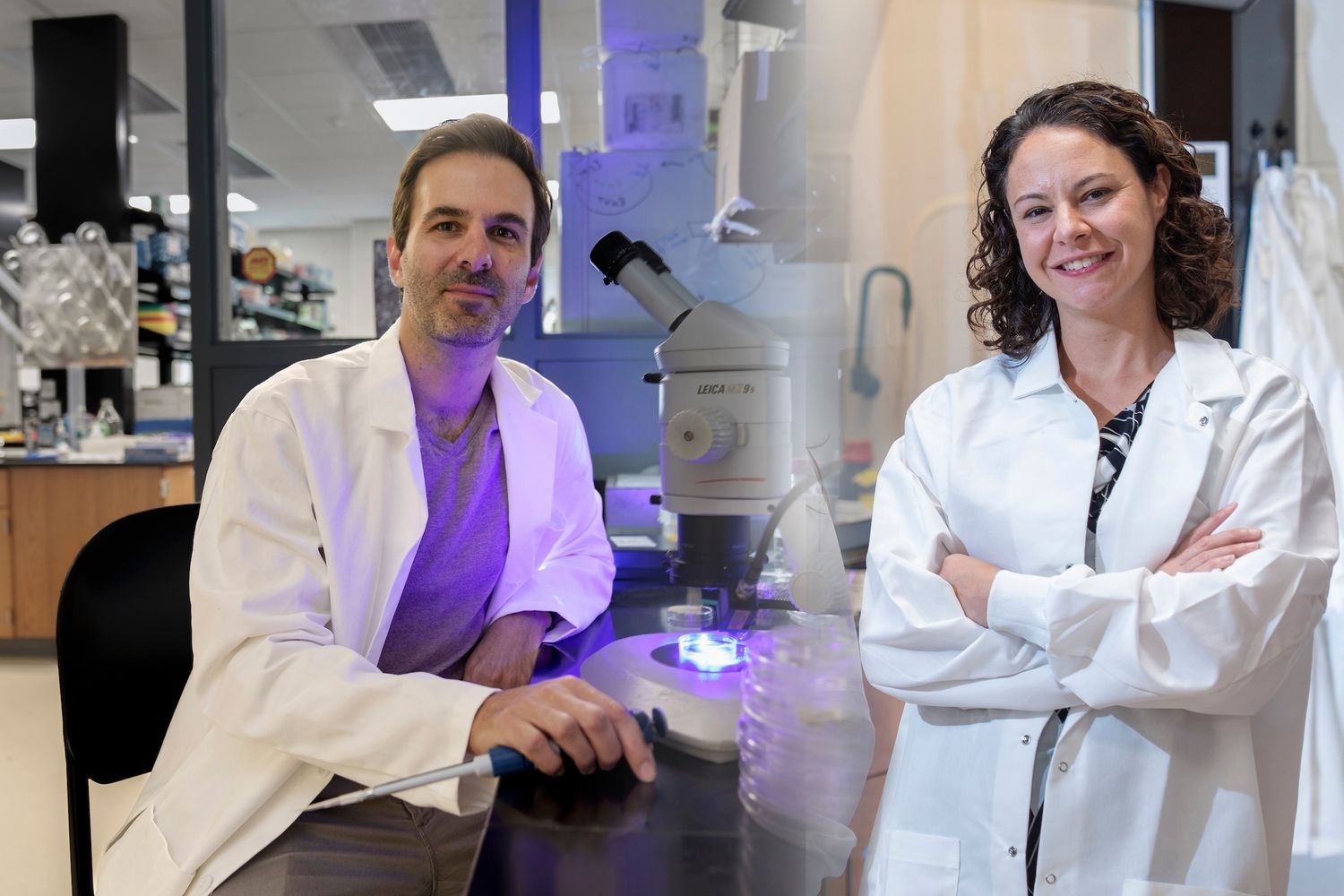 Associate Professors Jake Warner and Lori Schweikert pose in their lab coats.
