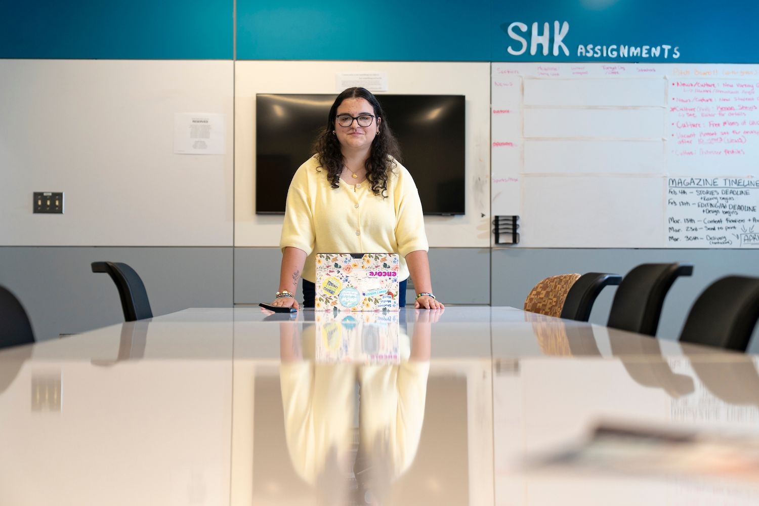 Student wearing a yellow shirt pose in a conference room
