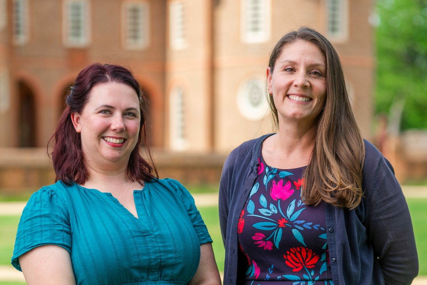 Caitlin Simpson (left) and Rachel West  (right) pose in front of a building in Colonial Williamsburg