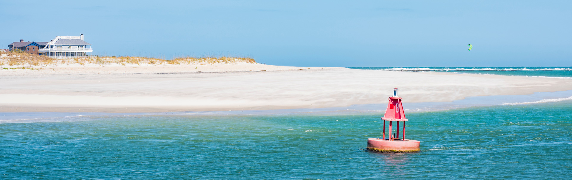 Channel marker floating in water near beach